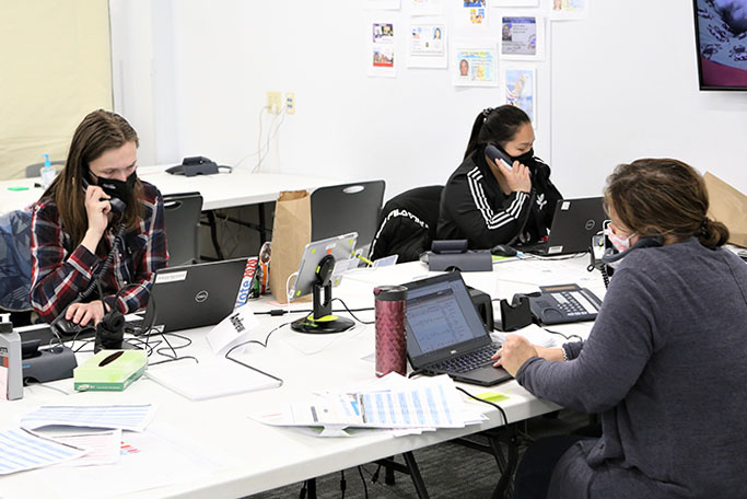 election staff sitting at a table on the phone