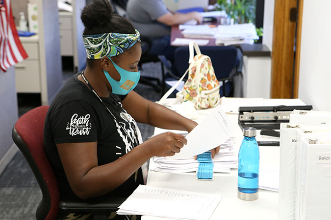 election worker sitting at table with paperwork