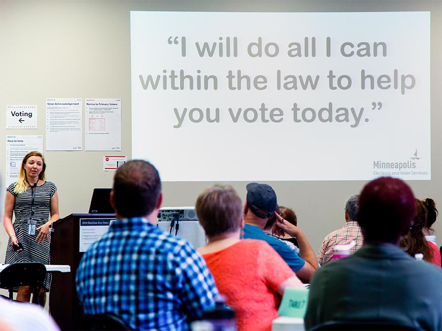 Election workers learn the motto 'I will do all I can within the law to help you vote today'